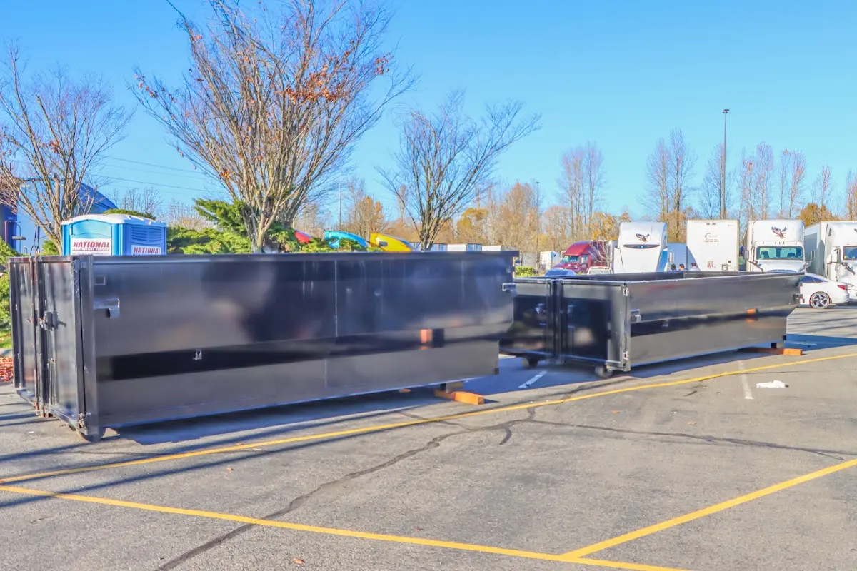 Professional dumpster rental service with roll-off container on residential driveway in Lake Jackson